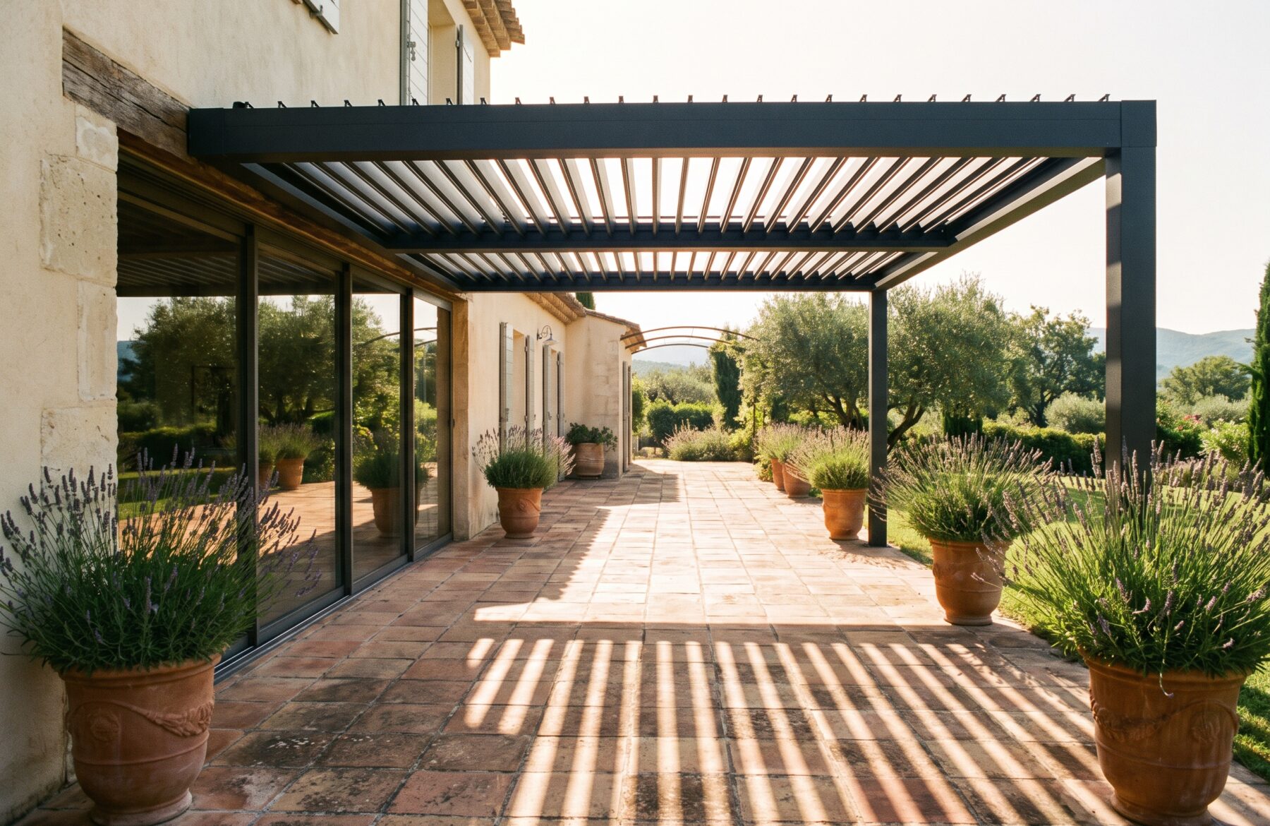 Pergola à lames orientables projetant une ombre rayée sur la terrasse devant une baie vitrée